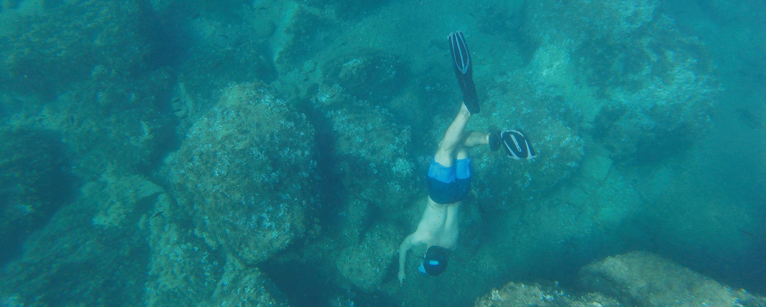 Una foto mia submergiendome hacia el fondo del mar usando tubo de buceo.